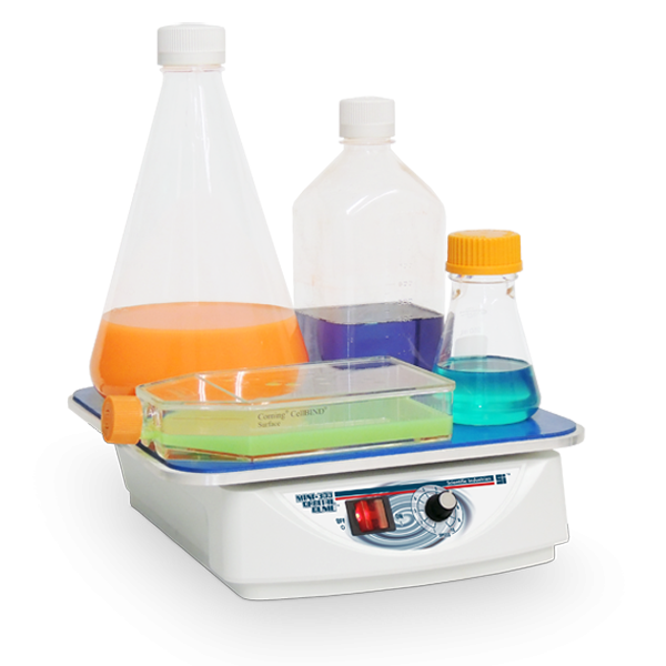 Lab hot plate with beakers containing colored liquids on a white background